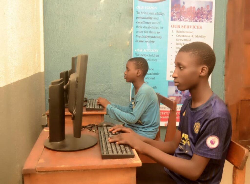 A picture of two of our beneficiaries operating computer in our computer lab